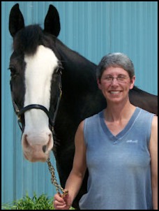 Women standing next to black horse